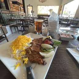 Boneless lamb kabobs with saffron rice, juicy barbecued tomato, onions and capsicum. SOMAGH & BREAD on the side.