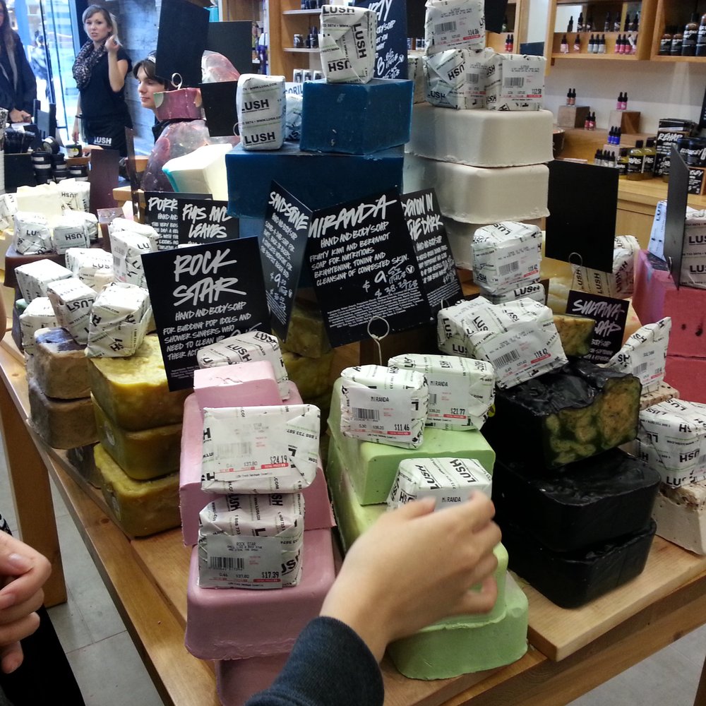 Lush Cosmetics - One of the many Lush tables with scented goodness. I'm targeting the scent called Miranda. - Cosmetics & Beauty Supply Near Me - San Diego, California Lush Cosmetics - One of the many Lush tables with scented goodness. I'm targeting the scent called Miranda. - Cosmetics & Beauty Supply Near Me - San Diego, California