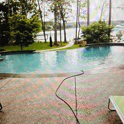 Michael Enterprises Pools and Spas - 18' x 36' free form with infinity edge looking toward the lake and bar area with stools in the pool.