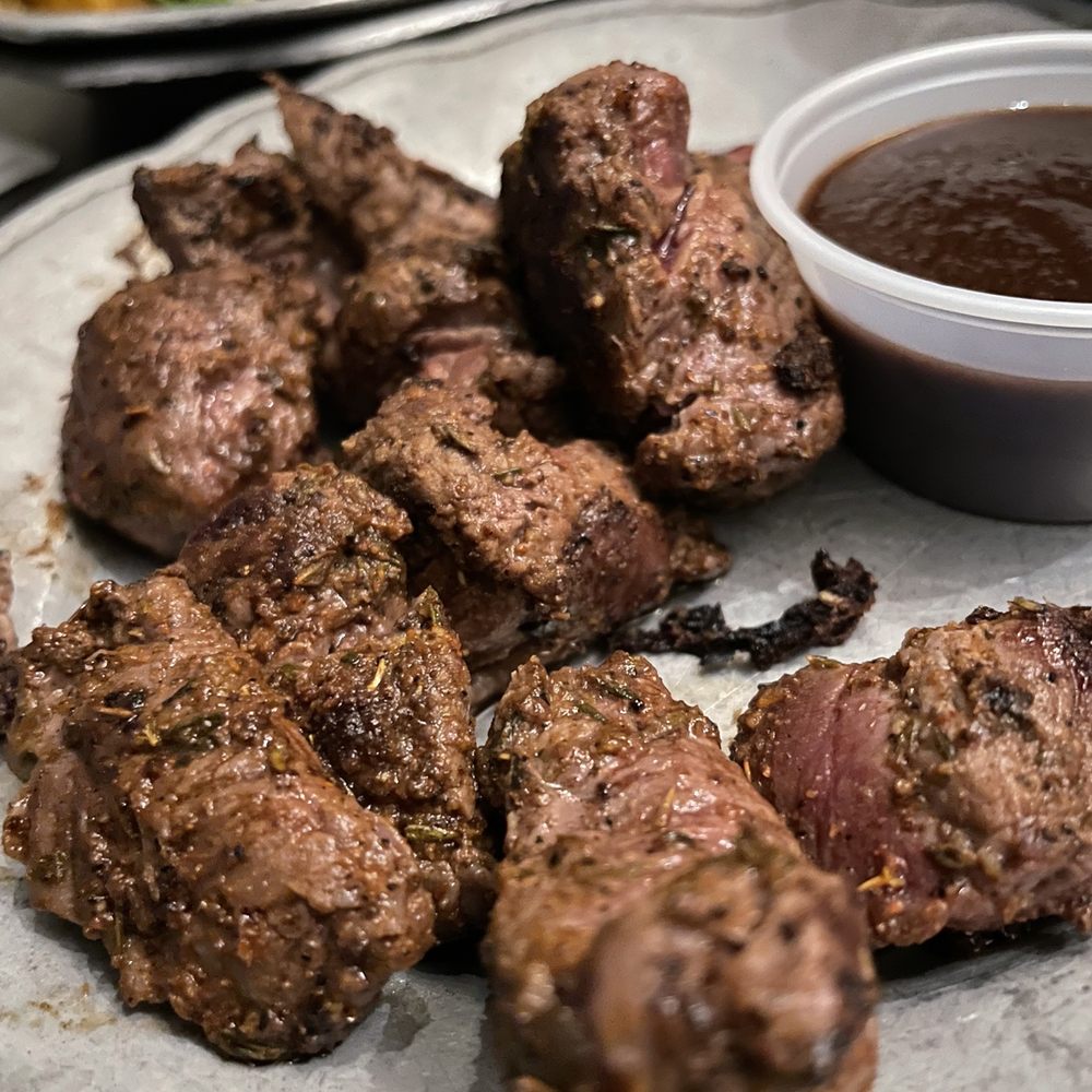 a plate of meat and a bowl of sauce a plate of meat and a bowl of sauce
