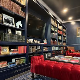 a library with red chairs and bookshelves