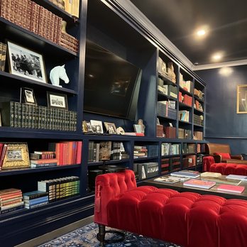 Simona's - a library with red chairs and bookshelves - Coffee & Tea Near Me - Austin, Texas
