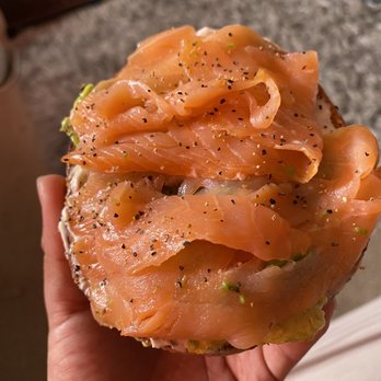 Sunrise Bagels - a hand holding a bagel with salmon - Bagels Near Me - Foothill Ranch, California