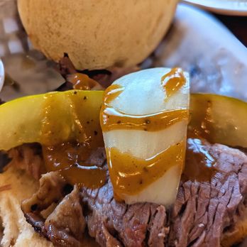 The Salt Lick BBQ - Brisket Sandwich opened up with onion, pickle spear, and BBQ sauce - Barbeque Near Me - Driftwood, Texas