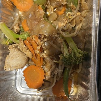 Sawasdee Danvers - Drunken noodles with chicken - A vegetable stir-fry with carrots, broccoli, bean sprouts, and pieces of chicken served in a foil container, likely from a takeout meal. - Thai Near Me - Danvers, Massachusetts
