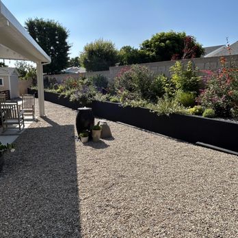 Carol Berglund Designs - a gravel patio with raised planters - Interior Design Near Me