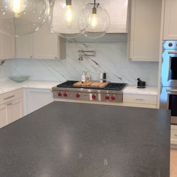 Black brushed granite island with Calacatta marble counter and backsplash and Zellij Gloss Oyster tile on the hood. Black brushed granite island with Calacatta marble counter and backsplash and Zellij Gloss Oyster tile on the hood.