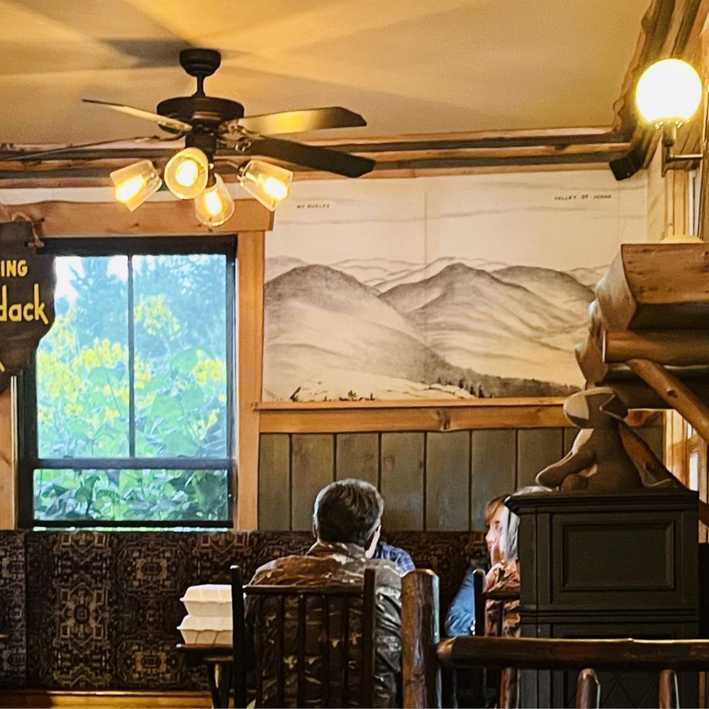 Forty Six - The decor complemented by the most beautiful tall yellow flowers outside the window - New American Near Me - Keene, New York