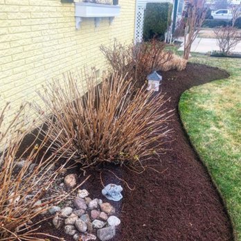 Lawncrafters - a front yard with mulch and shrubs - Lawn Services Near Me
