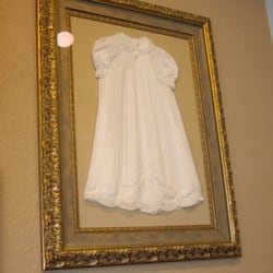 Here's a stunning example of framing an unusual item. An antique baby's christening dress, complete tiny gold baby necklace.