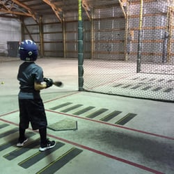Par Four Family Entertainment Center - Our son taking a few cracks at the 45 m.p.h. machine