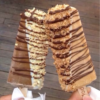 Popbar - Left: coffee popgelato with half white chocolate dip, hazelnut and almond topping and milk chocolate drizzle. - Desserts Near Me - Anaheim, California Popbar - Left: coffee popgelato with half white chocolate dip, hazelnut and almond topping and milk chocolate drizzle. - Desserts Near Me - Anaheim, California