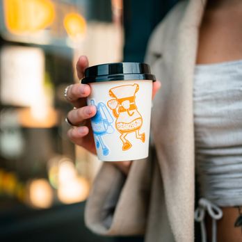 Buzz Cafe - a woman holding a cup of coffee - Coffee & Tea Near Me - Philadelphia, Pennsylvania
