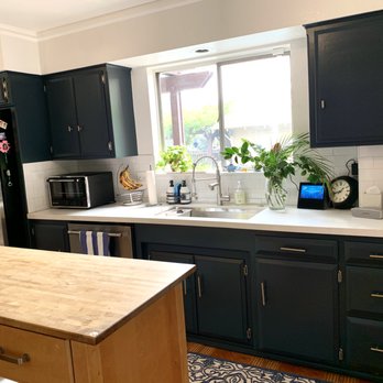 MasterWork - a kitchen with black cabinets and white countertops - General Contractors Near Me - Ontario, California