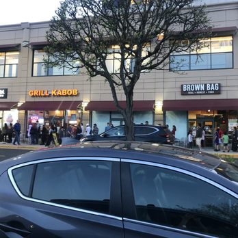 Crumbl - Reston - Crumbl on the left, with a line down the sidewalk for their Grand Opening! - Bakeries Near Me - Reston, Virginia