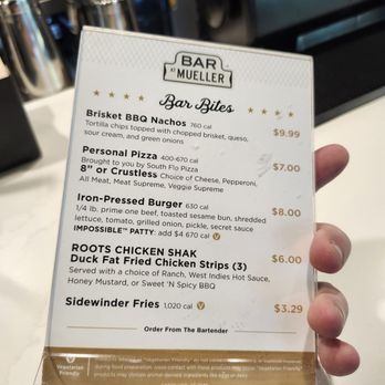 Bar at Mueller - Bar food. We had the chicken strips - A printed menu from Bar at Mueller in Austin, TX, listing bar bites such as brisket BBQ nachos, personal pizza, and chicken strips, with prices and calorie information. - Bars Near Me - Austin, Texas