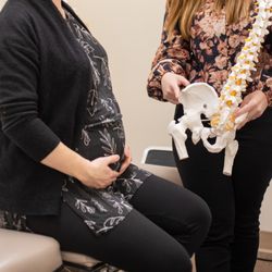 Broadmoor Chiropractic Massage Naturopathy - Dr Kim Castelo Branco providing an explanation into care to a pregnant patient