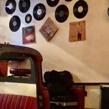 Cafe La Trova - Old car with albums and covers above - Cocktail Bars Near Me - Miami, Florida