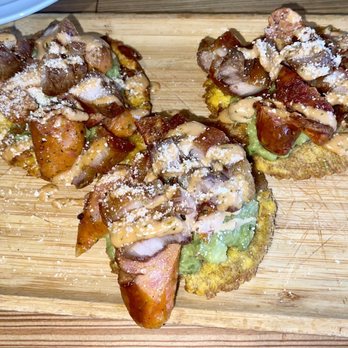 Arepalicious - a wooden cutting board with three sandwiches on it - Colombian Near Me - Ozone Park, New York