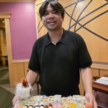 Cafe Asia 2 - My second Indonesian server, showing me, at my request, one of the Sushi trays order by a group seated at the third dining room. - Sushi Bars Near Me - Roanoke, Virginia