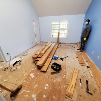 Millennium Flooring - a man standing on a hard wood floor - Refinishing Services Near Me - Hyannis, Massachusetts