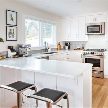 B Gallant Homes - a kitchen with white cabinets and stainless steel appliances - General Contractors Near Me - Nanaimo, British Columbia