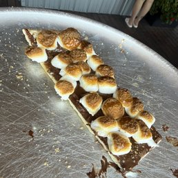 Last piece of the s'mores pizza! Nutella spread with crumbled graham crackers, marshmallows and a caramel drizzle.