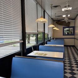 Delicious Deli - Seating on the side near the entrance, faces bushes and the intersection