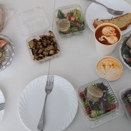 From left to right: slices of Challa, Tartine au Saumon sandwich, Pommes Florentine, side salad, Shakshuka, Grilled Chicken sandwich