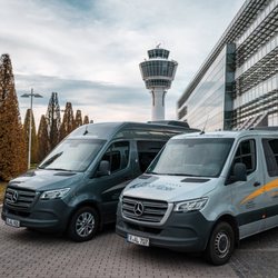 airportLiner Flughafentransfer - Zwei moderne & hochwertige airportLiner Mercedes-Benz Sprinter vorm Tower am Flughafen München