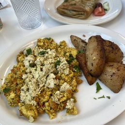 Tofu scramble, lemon potatoes, and spanakopita in the background. Tofu scramble, lemon potatoes, and spanakopita in the background.
