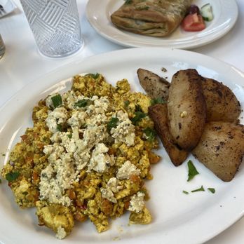 Voula's Greek Sweets - Tofu scramble, lemon potatoes, and spanakopita in the background. - Desserts Near Me - Rochester, New York Voula's Greek Sweets - Tofu scramble, lemon potatoes, and spanakopita in the background. - Desserts Near Me - Rochester, New York