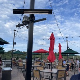 people sitting at tables and umbrellas people sitting at tables and umbrellas