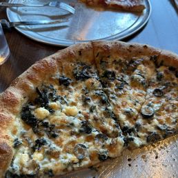 Greek pizza with a pepperoni gluten-free in the background.