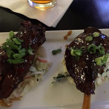 Spectators - Pork wings with seaseme and green onions, laying on a coleslaw base. You get 3 in a serving. - American Near Me - Kansas City, Missouri