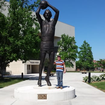 Hulman Center - a young boy standing in front of a statue of a basketball player - Music Venues Near Me - Terre Haute, Indiana