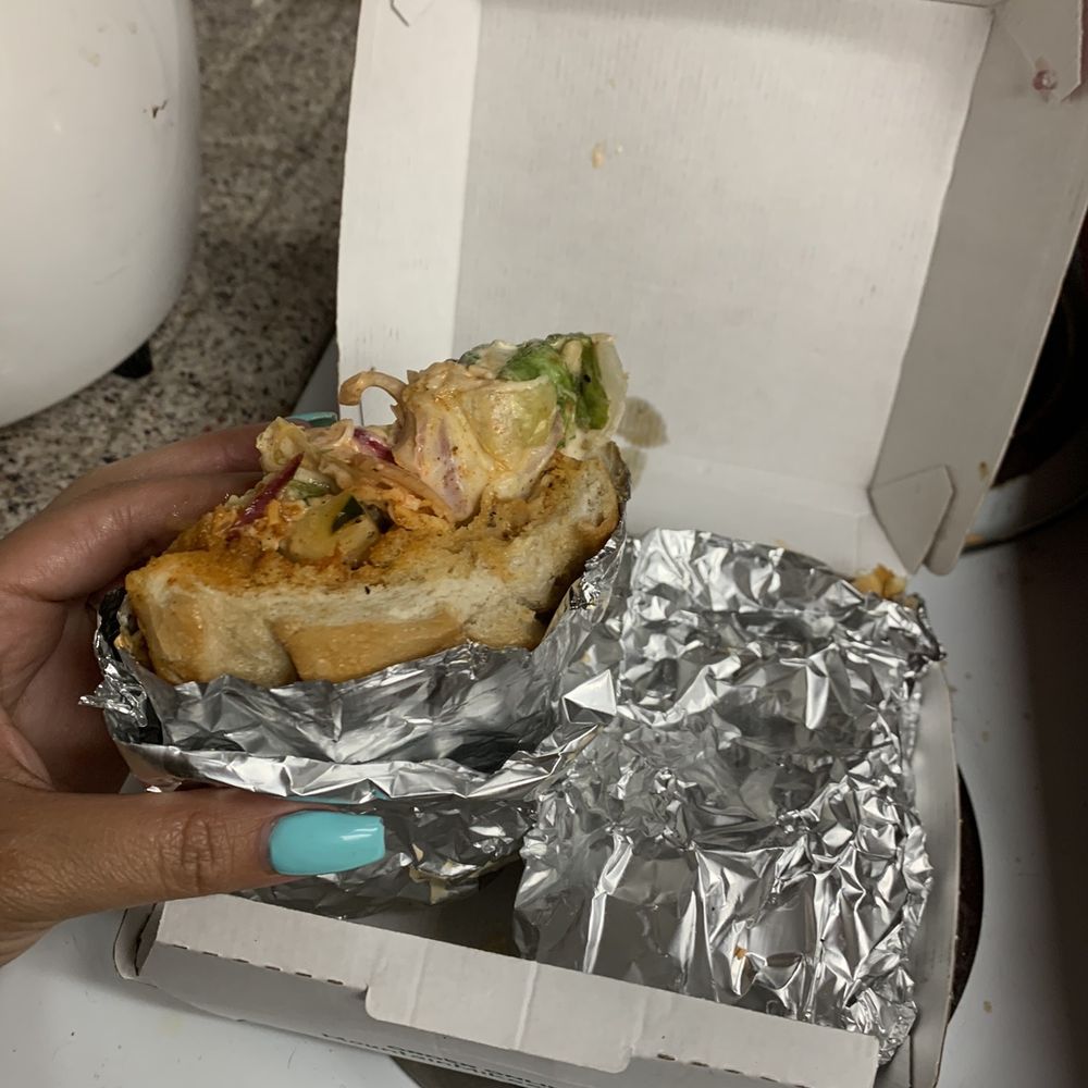 a person holding a sandwich in a box a person holding a sandwich in a box