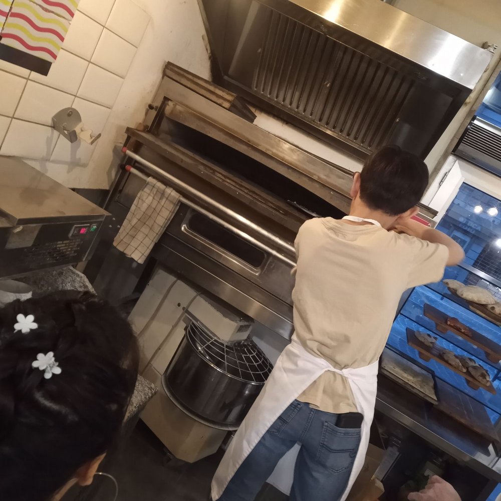 Pinsa - Placing pizza in oven - Pizza Near Me - Padova, PD Pinsa - Placing pizza in oven - Pizza Near Me - Padova, PD