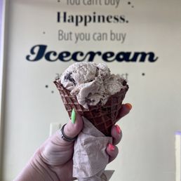 a hand holding an ice cream cone