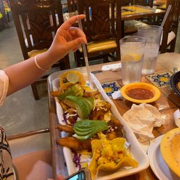 a woman sitting at a table with a plate of food a woman sitting at a table with a plate of food