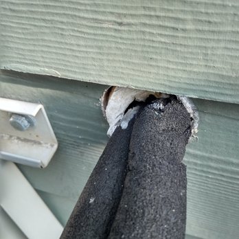 Dorset Landscaping - Heat pump and pipe pushed into the side of the garage where Winston had his "Ditch Witch" excavating. - Landscaping Near Me