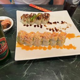a plate of sushi and a bottle of beer
