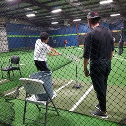 Student getting batting instruction from Coach Hill.