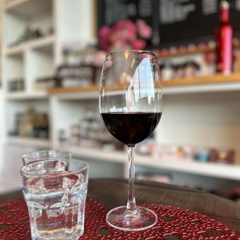 Cork & Knife - a glass of wine on a table - Wine Tasting Room Near Me - Clovis, California