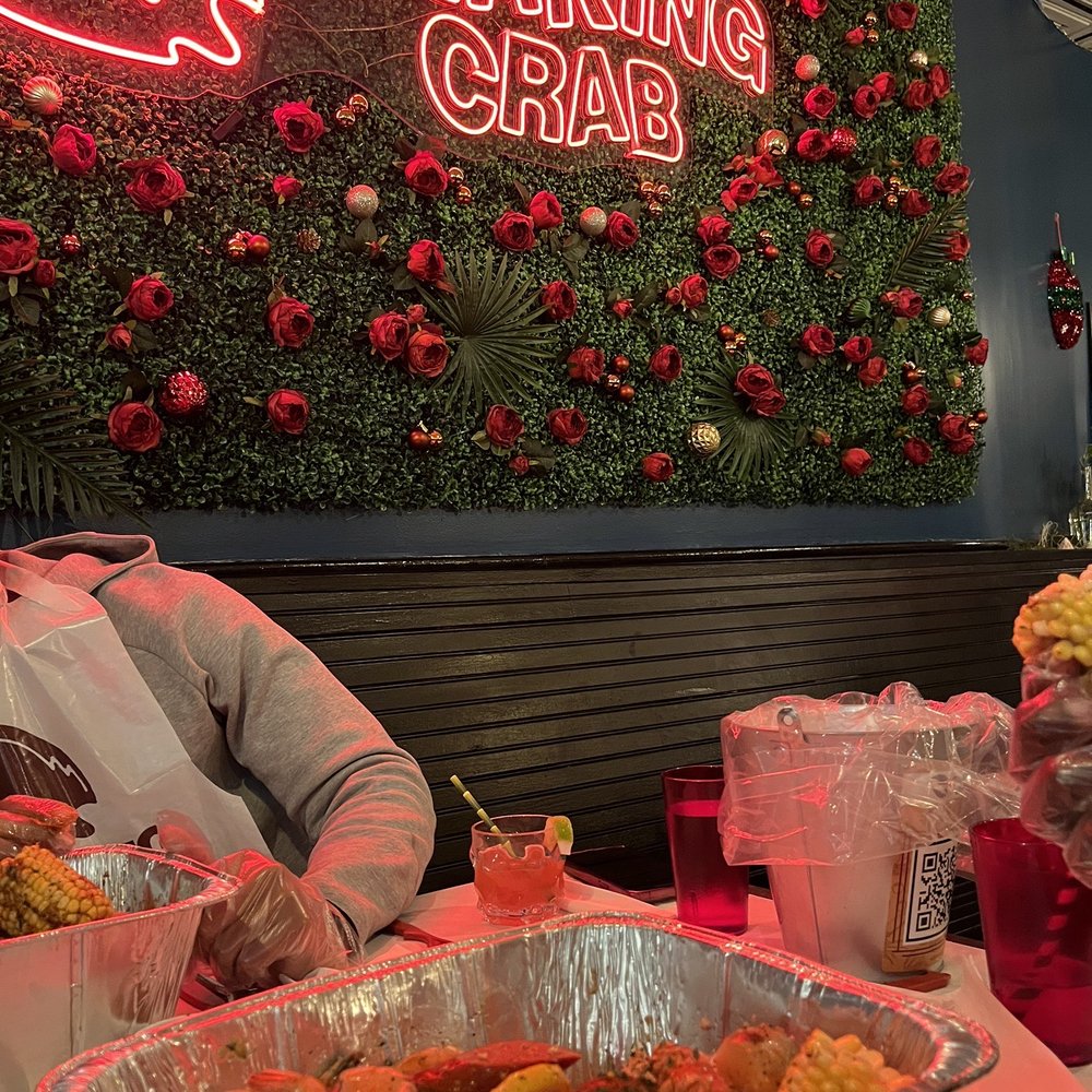 Shaking Crab - Williamsburg - a man sitting at a table with food - Seafood Near Me - New York, New York Shaking Crab - Williamsburg - a man sitting at a table with food - Seafood Near Me - New York, New York
