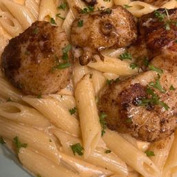 Seared scallops over penne with a cajun cream sauce. Seared scallops over penne with a cajun cream sauce.