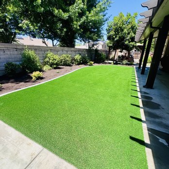 Pablo’s Landscaping & Concrete  - Primary yard with artificial turf, concrete curbing, drip irrigation and humus/bark in the flower beds. - Irrigation Near Me