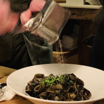 Ulivo - Tagliatelle al Nero di Seppia (black squid ink pasta; waiter adding cheese, because my friend demanded it lol) - Italian Near Me - New York, New York Ulivo - Tagliatelle al Nero di Seppia (black squid ink pasta; waiter adding cheese, because my friend demanded it lol) - Italian Near Me - New York, New York