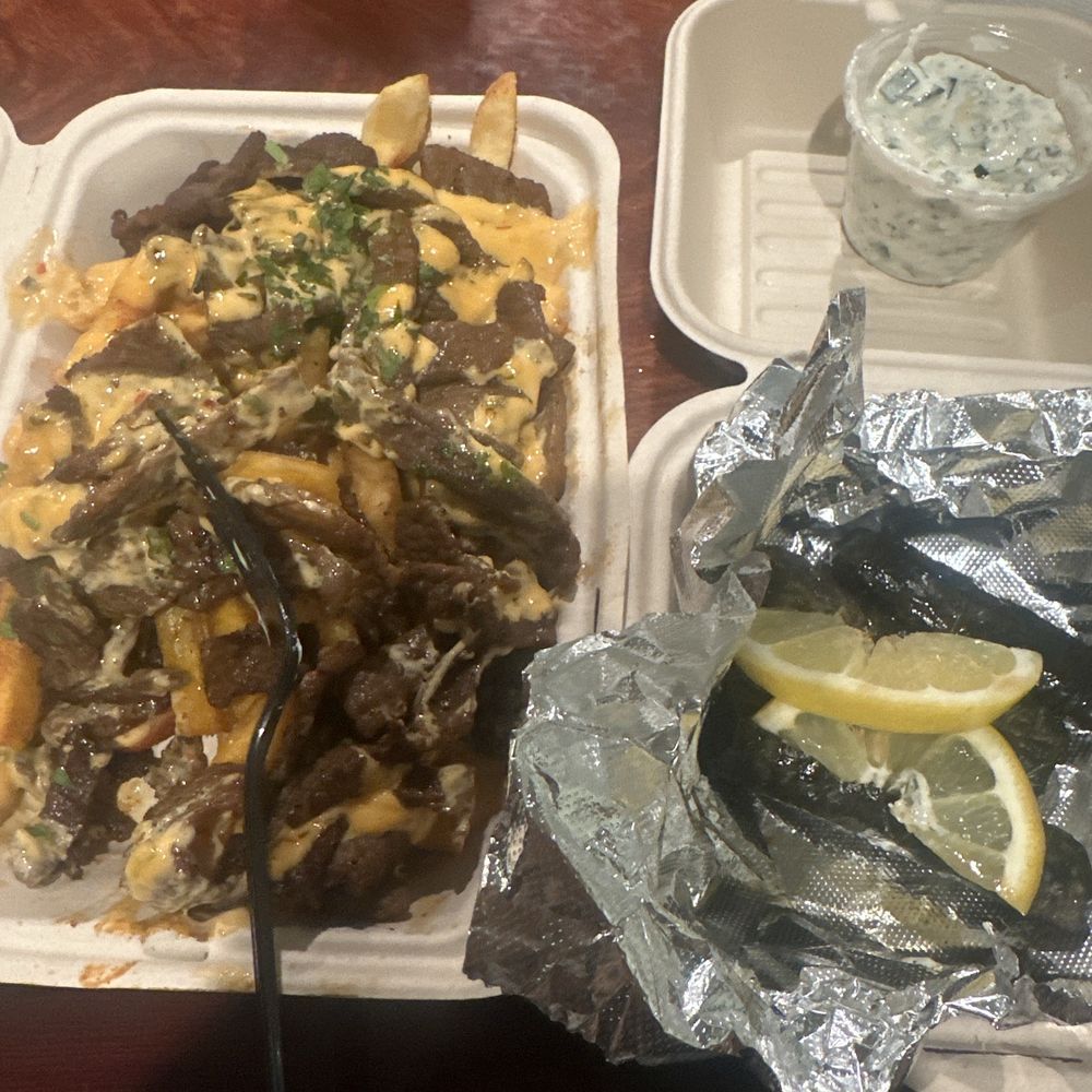 Fries with beef shawarma on top with sarma on the side
