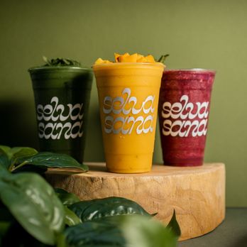 Selva Sana - three smoothie cups on a wooden stand - Juice Bars & Smoothies Near Me - Atlanta, Georgia